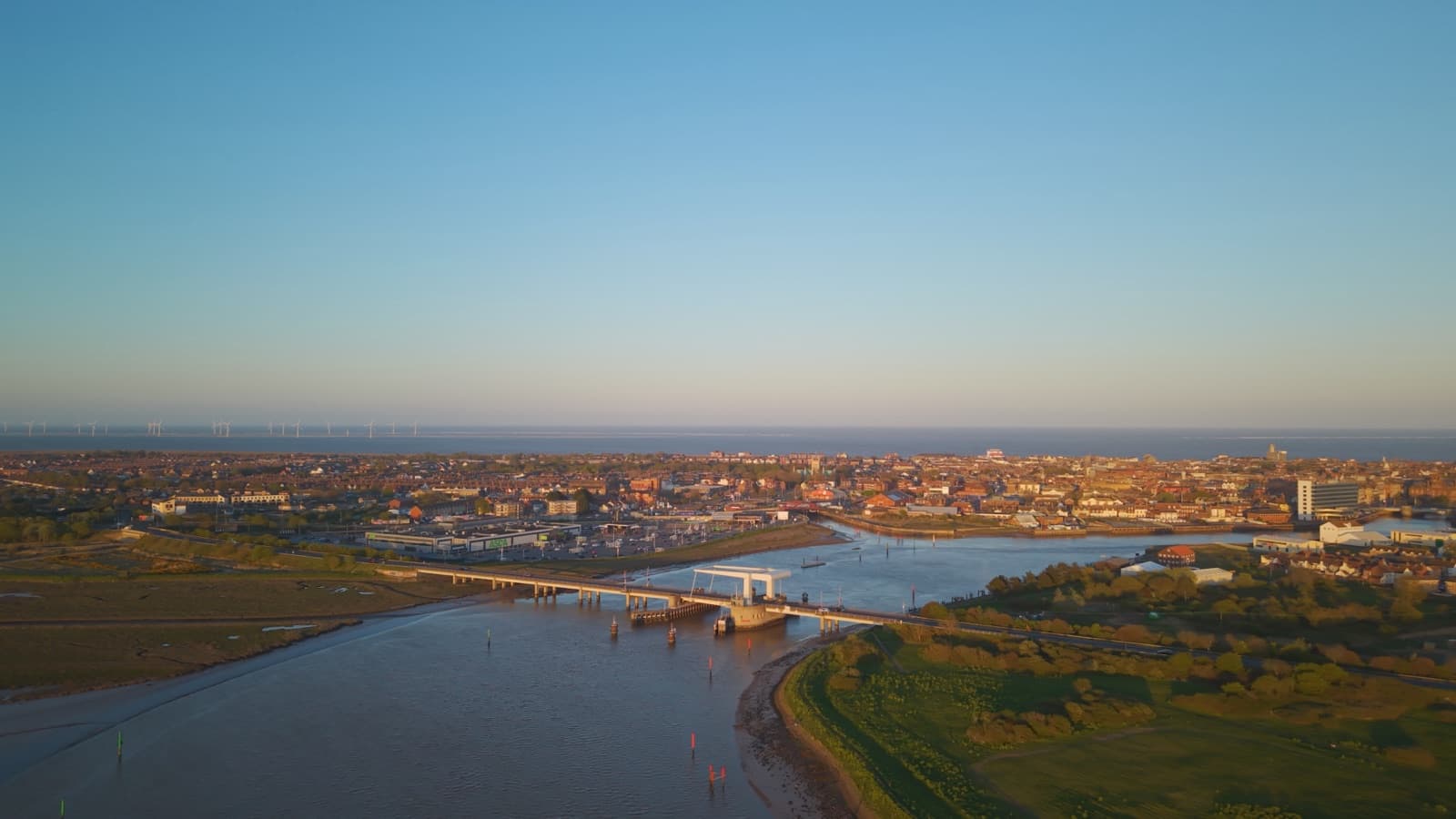 Breydon Bridge and Great Yarmouth at sunset, seen from above the water — litigation and dispute resolution solicitors in Norfolk and Suffolk