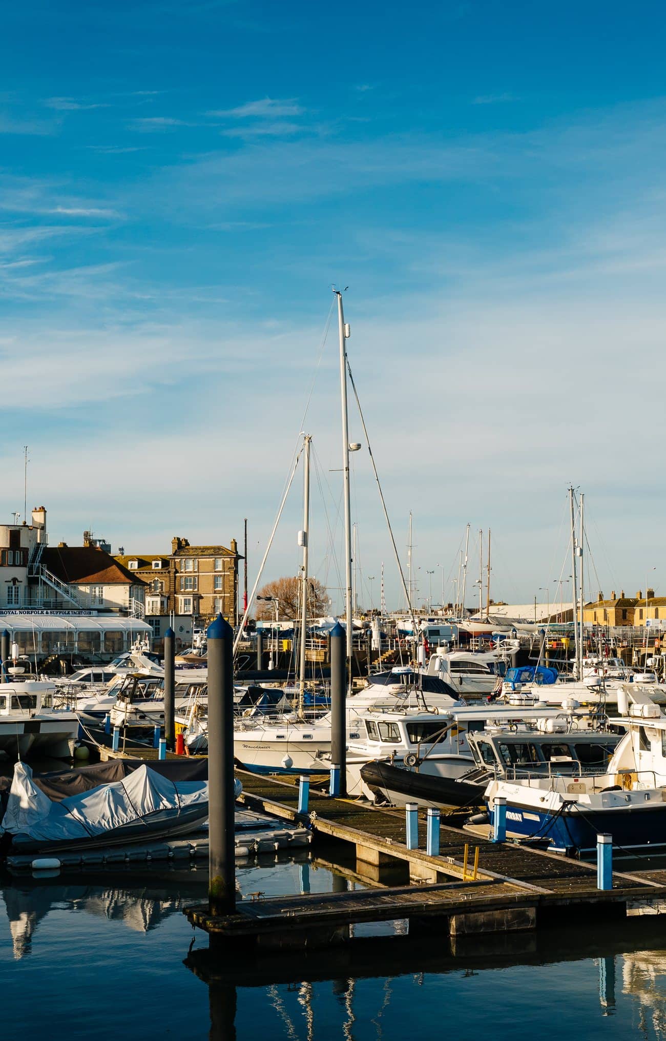Boats moored in Lowestoft marina on a bright winter morning, with the town behind