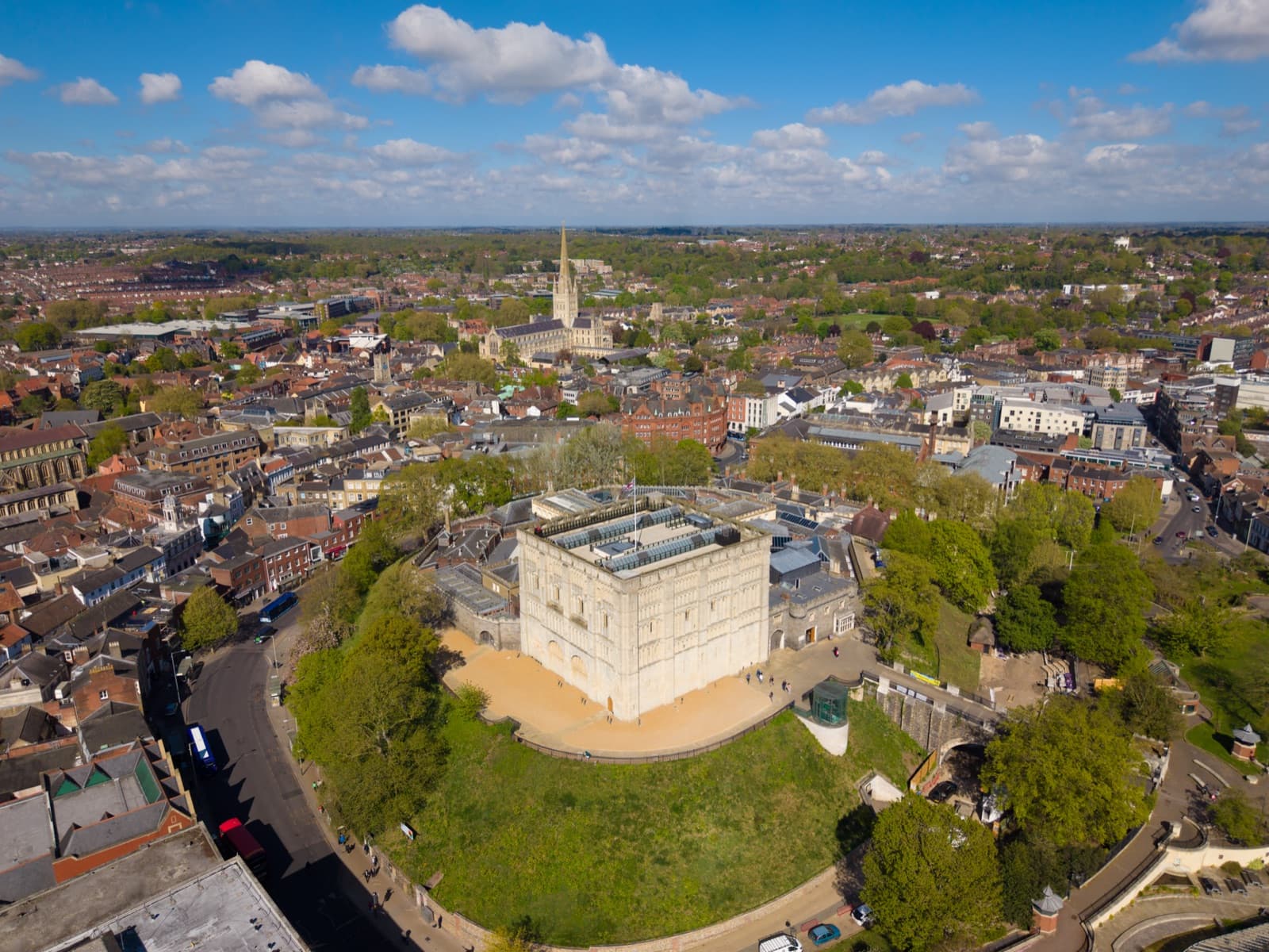 Norwich Castle on its mound above the city rooftops, with the cathedral spire beyond — debt collection solicitors in Norwich and Lowestoft